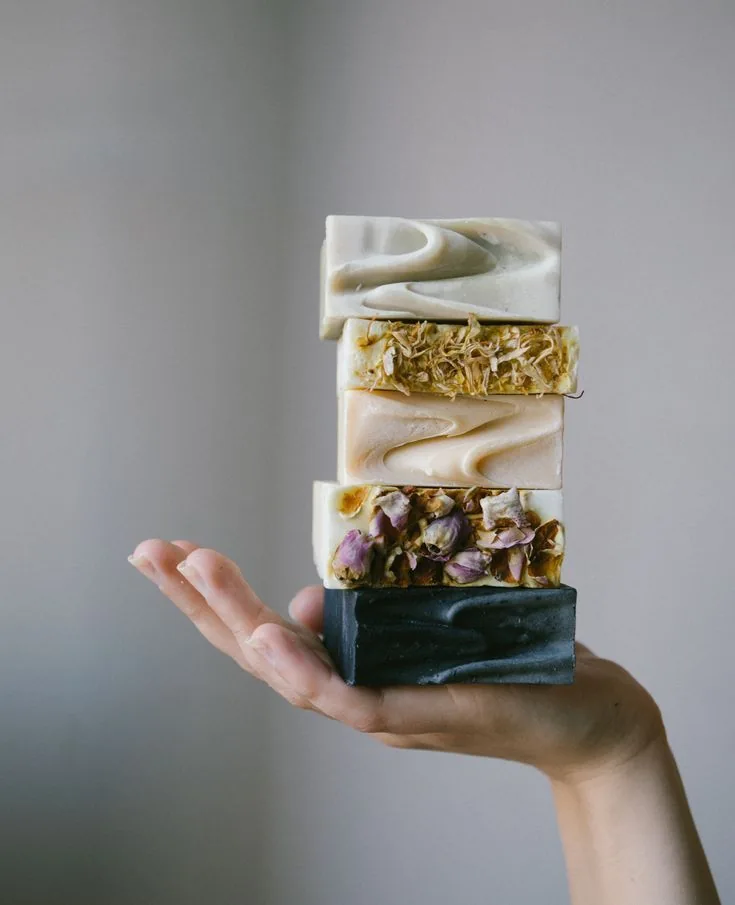A hand holding a stack of soap bars